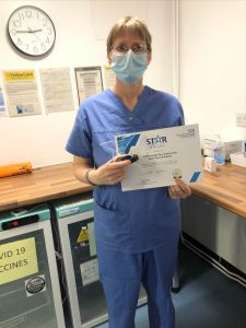 Nurse holding Star Award certificate