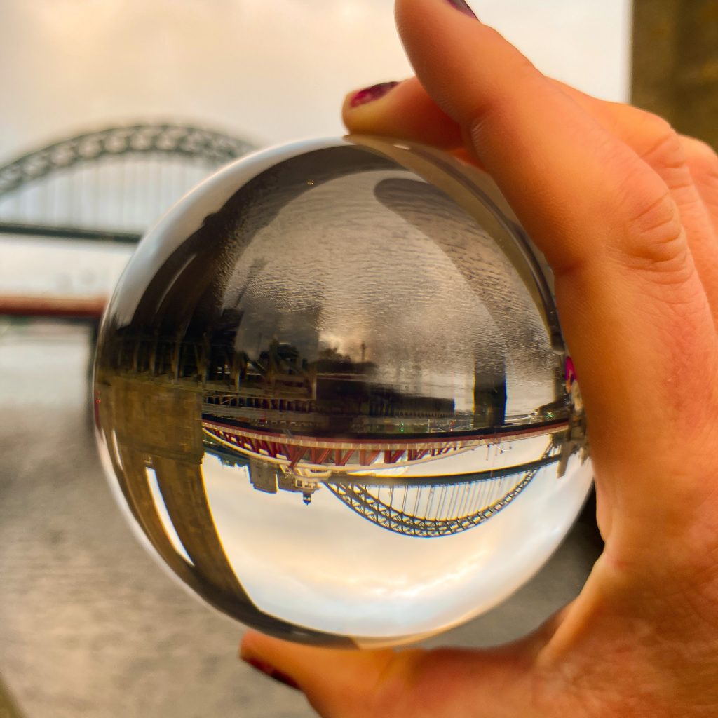 A photo of the Newcastle bridges reflected in a silver ball