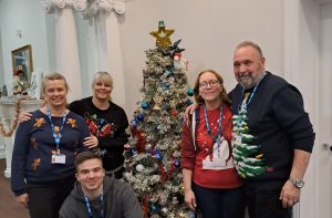 Staff pictured with the tree decorated by members of the participation group.