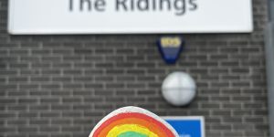 A painted rainbow on a rock held up at the front of The Ridings sign at CAMHS in Redcar