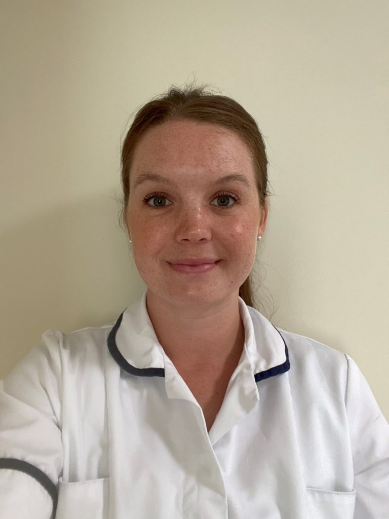 Jestine Craigs specialist learning disability physiotherapist. In a white uniform with brown hair tied back