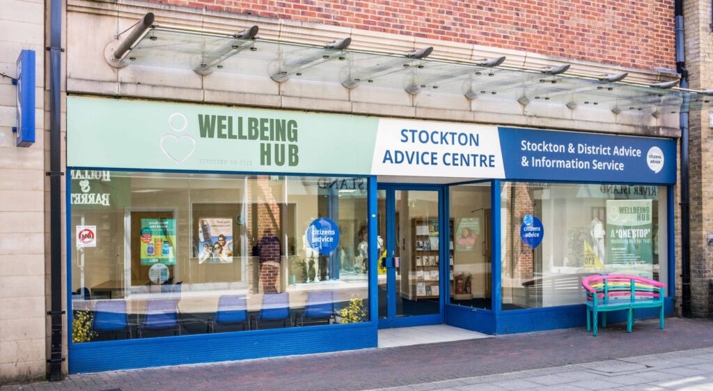 Picture of the outside of the Stockton wellbeing hub. A blue building with glass windows and doors.