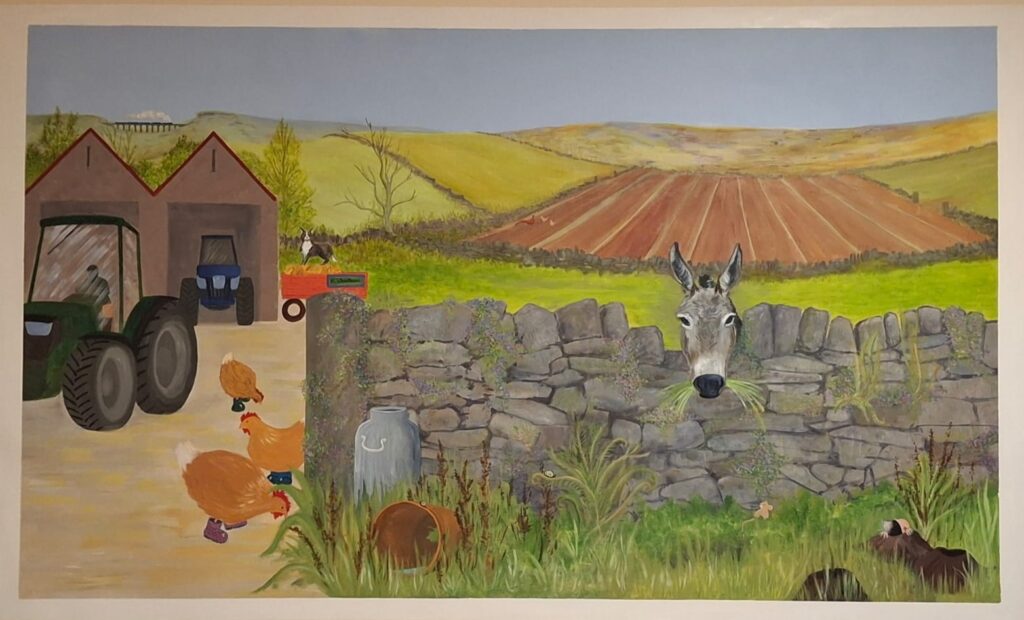Full image of the farmyard and countryside mural that includes a donkey looking over the wall