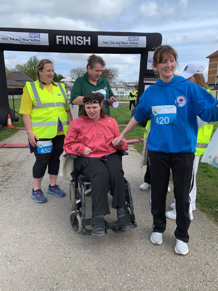Sue, Christine and other supporters crossing the finish line.