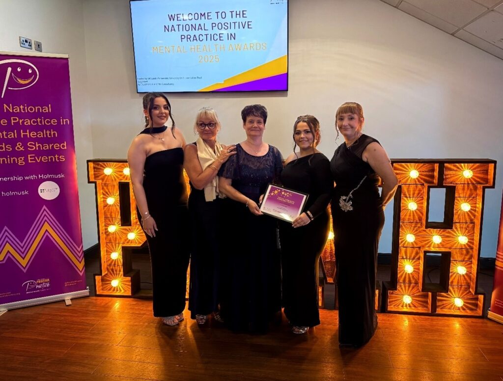 Staff from Elm Ward holding their award certificate