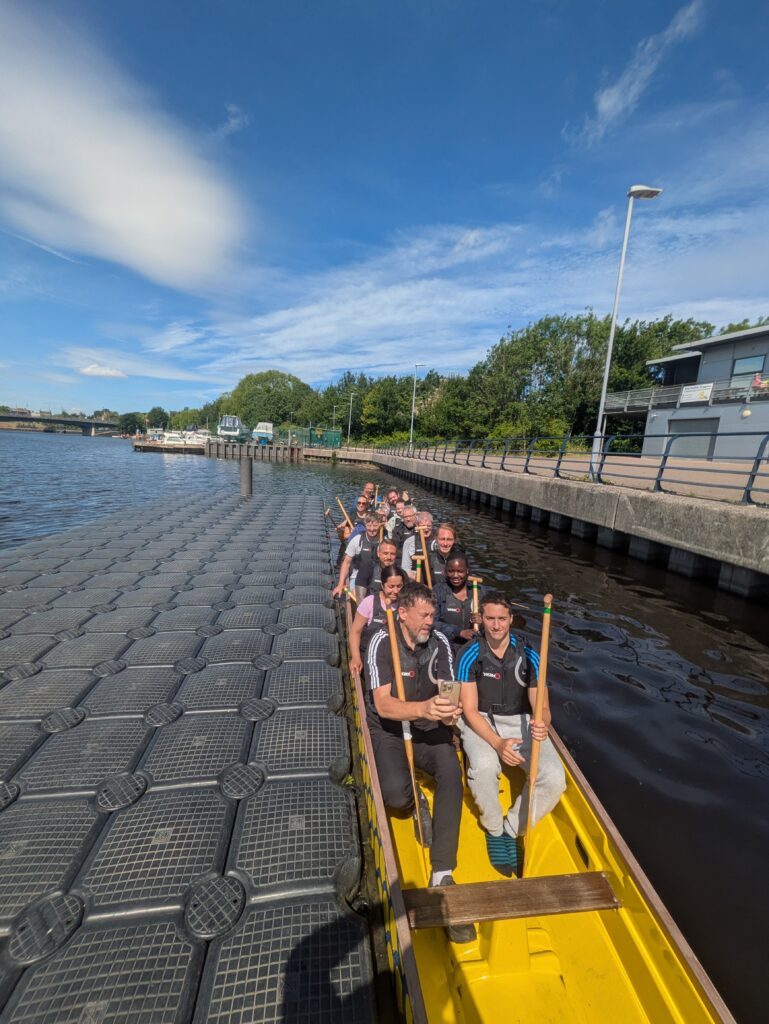 EIP staff and patients sat in the long Dragon Boat ready to set off