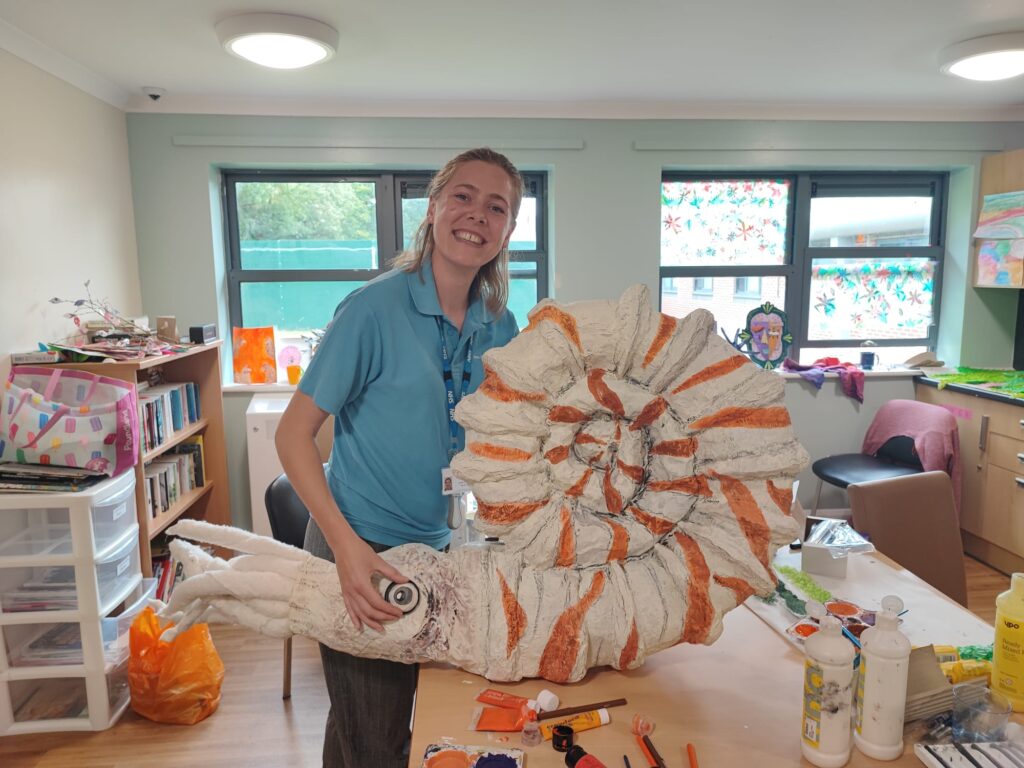 Staff member holding the large seashell