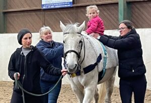 Paige enjoying hippotherapy - a type of therapy on horseback, which helps her muscles relax.