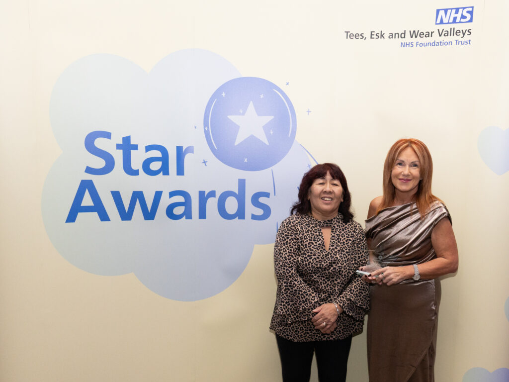 Members of Woodside Dementia hub smiling with a star award.