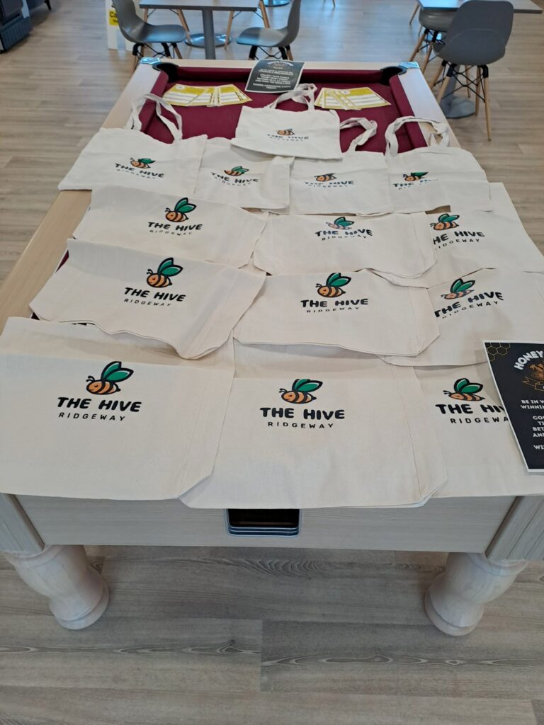 The Hive shopping bags with logo on them