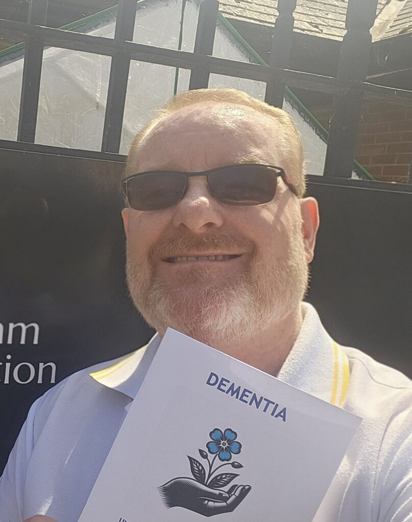 Michael Booth with the information booklet he wrote about dementia.