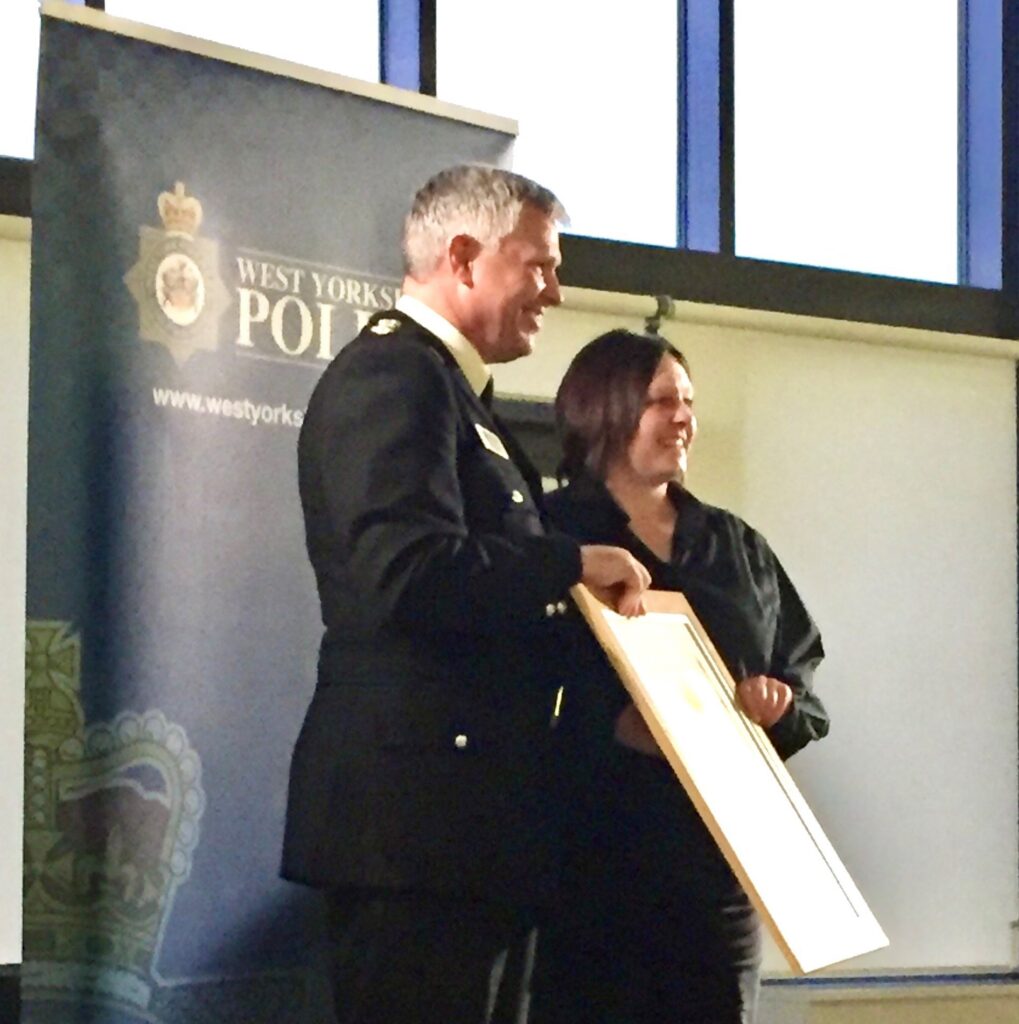 Julia being awarded a bravery award by the police after helping people in the street following an incident.