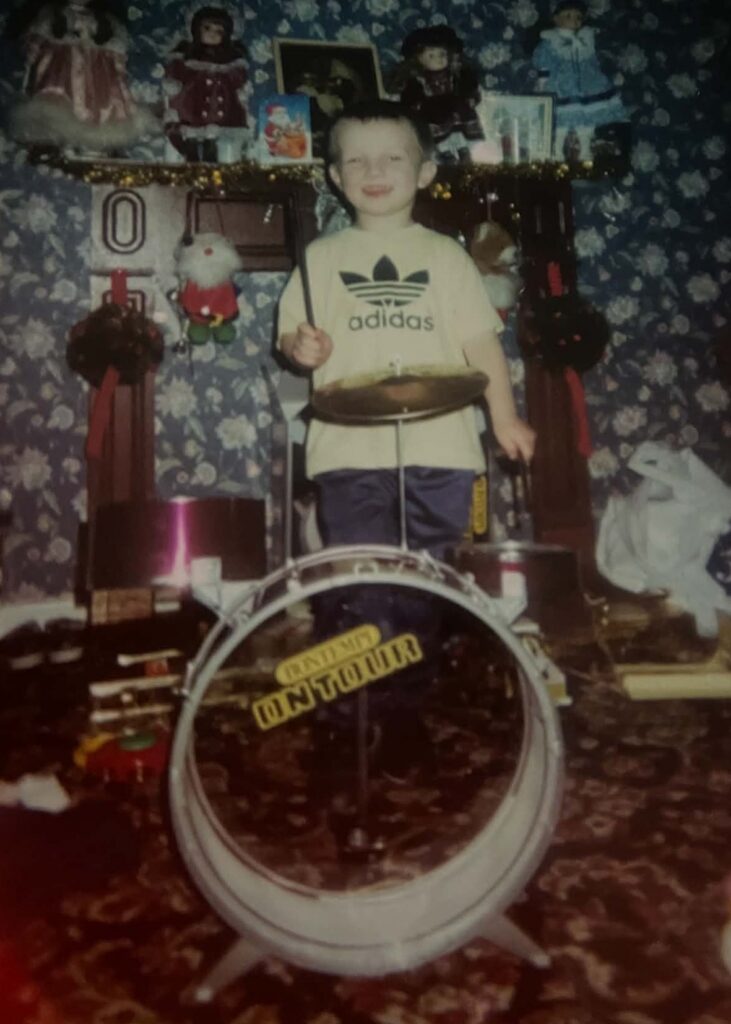 Kevin Pickard as a young boy playing the drums