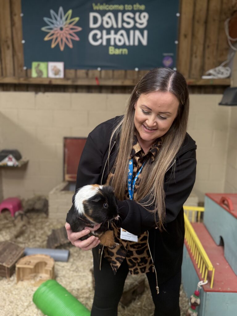Member of trust staff holding a small pet