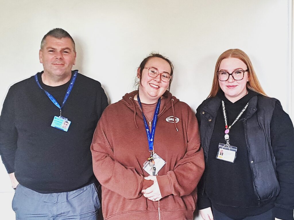 A man stood with two ladies, all of which are new peer support workers