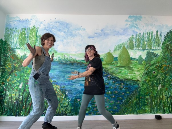 Griselda with Becca in front of the mural