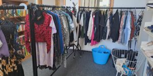 Some of the clothing items available on a rail