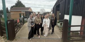 Trust and Daisy Chain staff under the main entrance sign go Daisy Chain