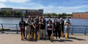 EIP staff and patients stood in a group wearing their lifejackets and holding paddles.